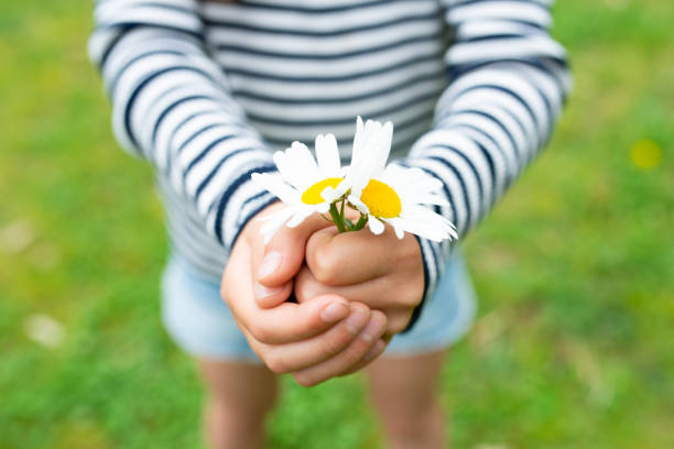 istock Child holding flowers 1222764614