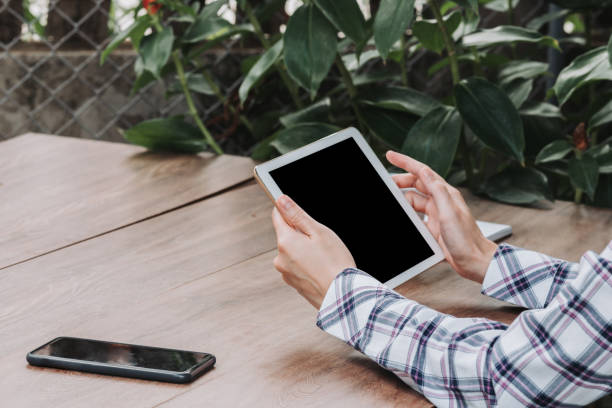 istock Woman hand holding tablet on wooden table at work from home. 1222766444