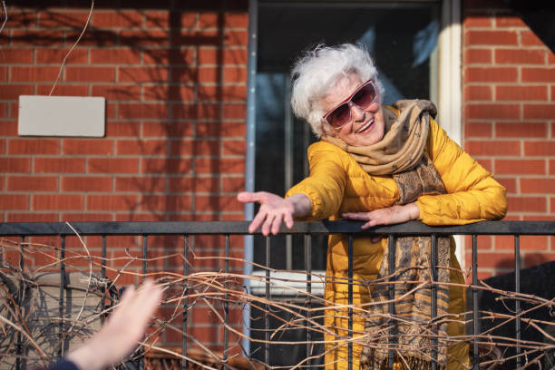 Quarantined senior woman, photographed through window and on the balcony, Covid-19, Quebec, Canada