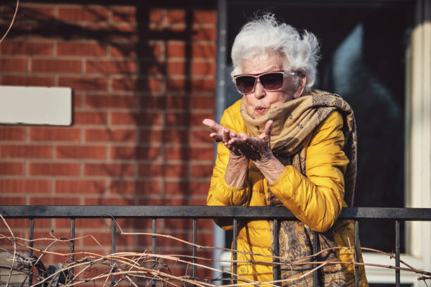 Quarantined senior woman, photographed through window and on the balcony, Covid-19, Quebec, Canada
