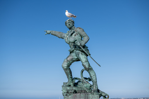 Statue of the corsair Surcouf in Saint Malo with a gull on its head, France