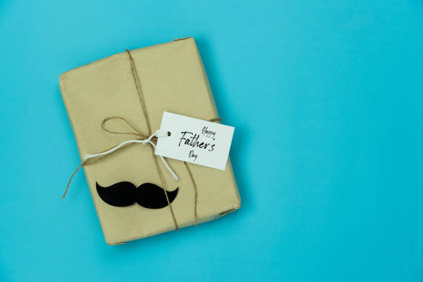 istock Table top view Happy Fathers day holiday background concept.Flat lay  gift box & greeting card for dad with accessories objects sign of season on modern rustic blue paper at home office desk. 1222771624
