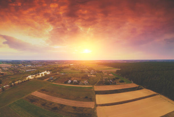 istock Panoramic view from above of countryside, arable fields, and pine forest in the spring evening. Beautiful dramatic sky at a blazing sunset 1222771649