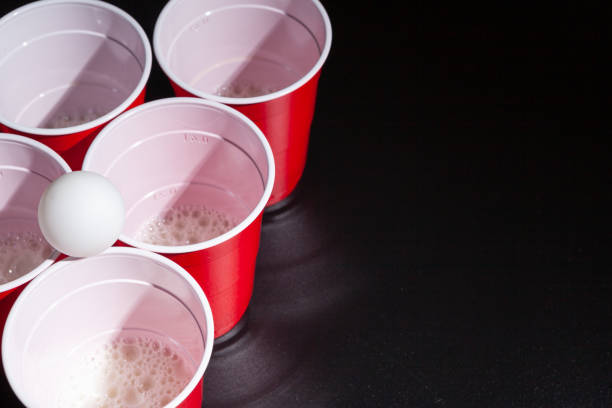 jeu d’université de pong de bière sur le fond noir - disposable cup plastic beer bottle photos et images de collection