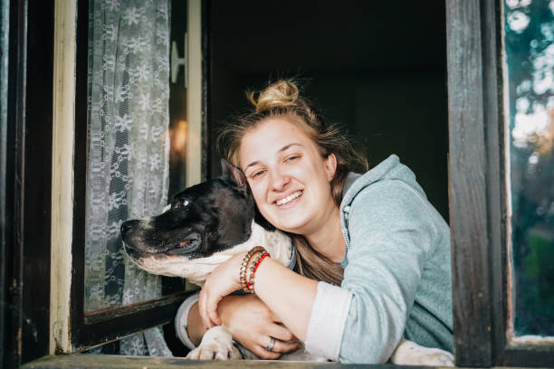 istock Dog and young female look out a home window 1222772368
