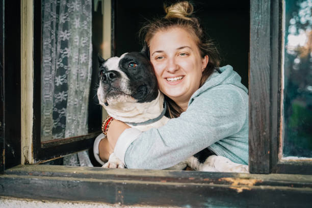 istock Dog and young female look out a home window 1222772371