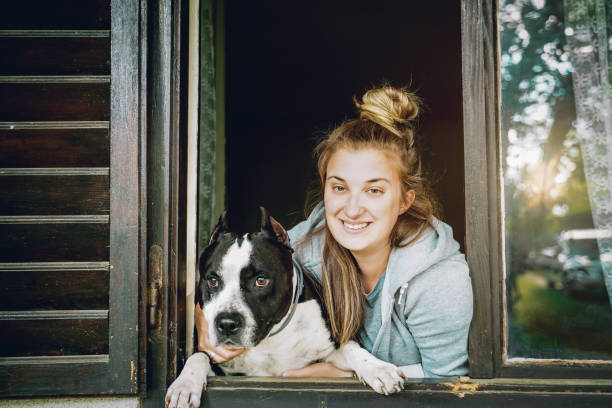 istock Dog and young female look out a home window 1222774957