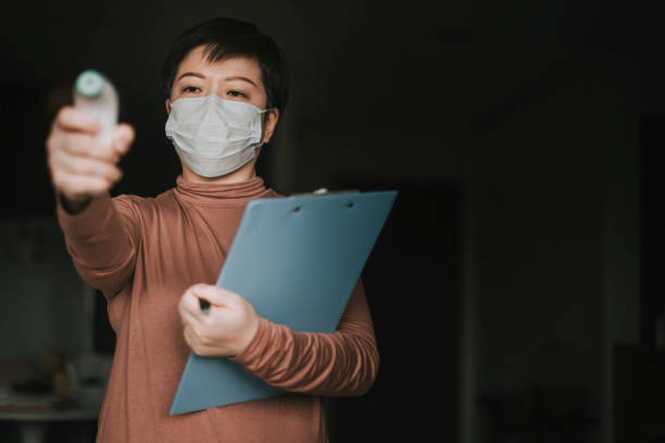 istock measuring body temperature using digital infrared thermometer for prevention and security measurement precaution 1222777412
