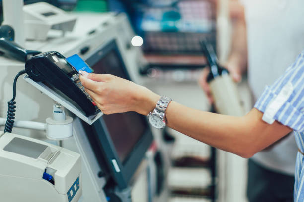 Couple with bank card buying food at grocery store or supermarket self-checkout Couple with bank card buying food at grocery store or supermarket self-checkout self checkout stock pictures, royalty-free photos & images