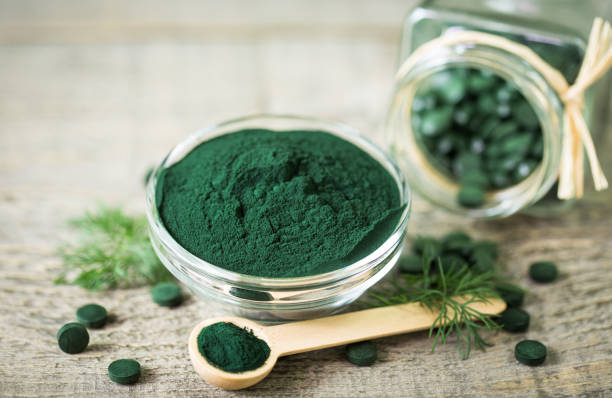 istock Spirulina tablets and powder in bowls 1222786634