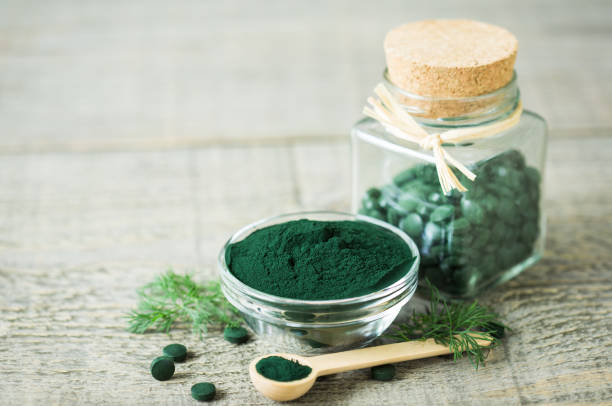 istock Spirulina tablets and powder in bowls 1222786639