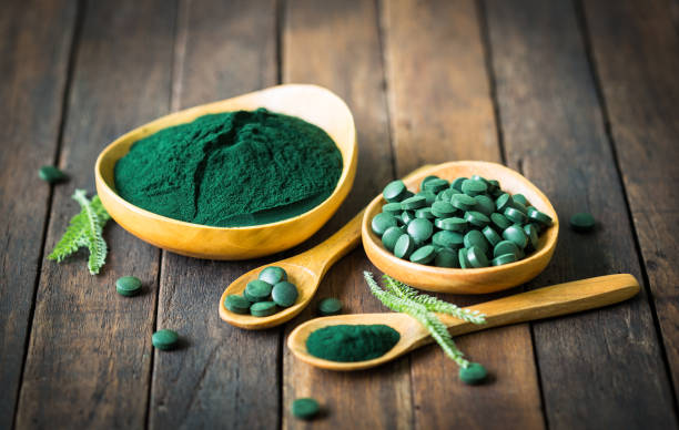 istock Spirulina tablets and powder in bowls 1222786678