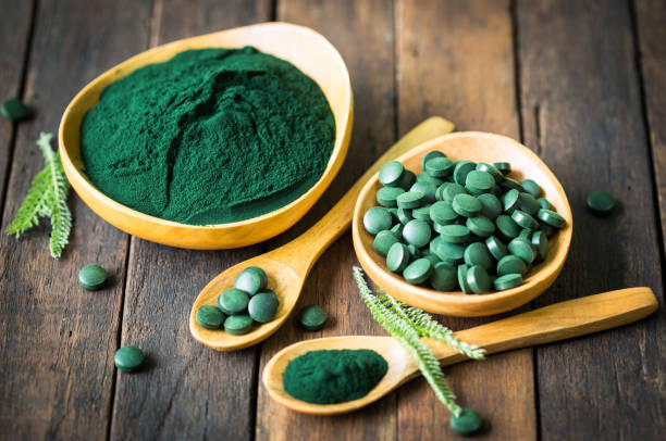istock Spirulina tablets and powder in bowls 1222786756