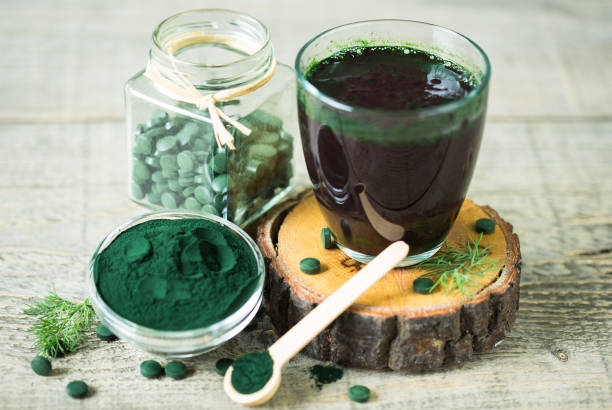 gesunde spirulina getränk im glas - chlorophyll green smoothie smoothie vegetable stock-fotos und bilder