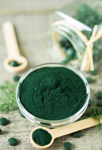istock Spirulina tablets and powder in bowls 1222786831