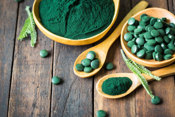 istock Spirulina tablets and powder in bowls 1222786885