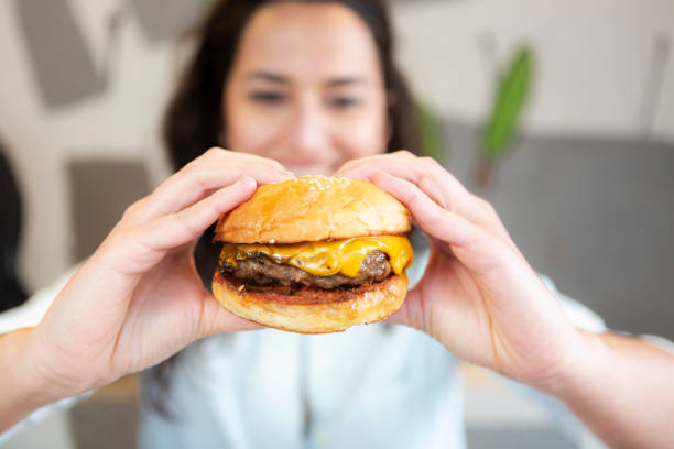 istock Woman eating beef burger 1222787015