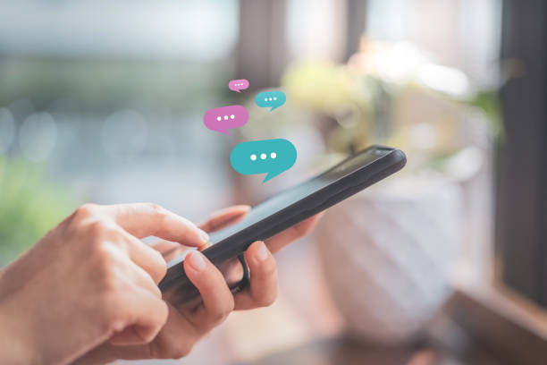 istock Woman hand using smart phone with chat icon graphic at coffee shop abstract background. 1222788467