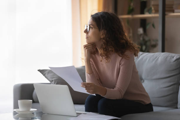 istock Distracted from work or study young pretty woman looking away. 1222788476