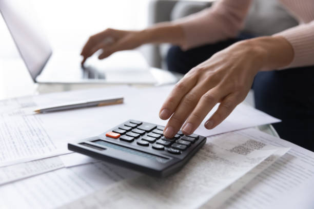 istock Close up focus on female hands making calculations. 1222788494