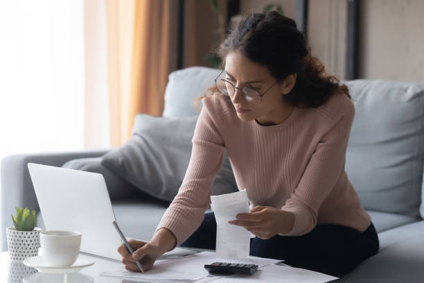 istock Young lady managing incomes and outcomes at home. 1222788496