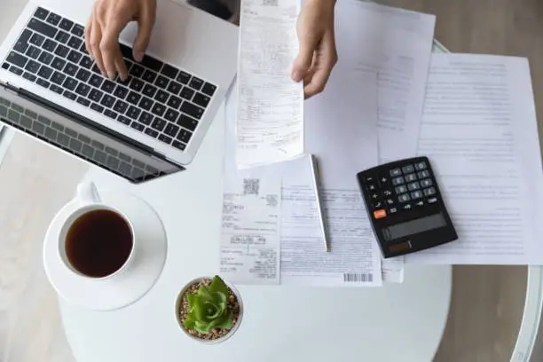 Photo of Above top view close up young woman managing monthly expenses.