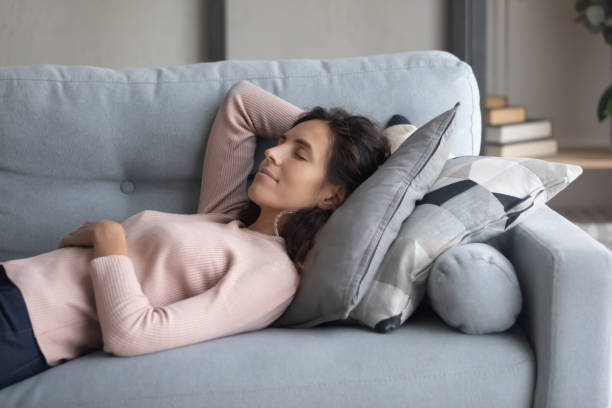 istock Calm pleasant millennial girl napping daydreaming alone on couch. 1222788529