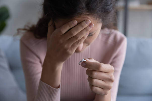 istock Desperate millennial woman holding engagement ring in hand. 1222788535