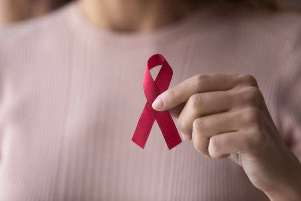 istock Close up focus on red ribbon in female hands. 1222788539