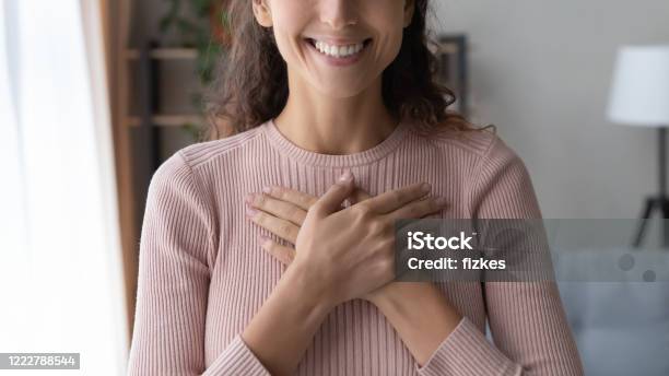 Close Up Happy Sincere Female Holding Folded Hands On Chest Stock Photo - Download Image Now