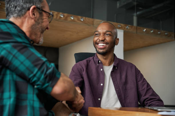 young trendy black african shaking hands and smiling during interview - gesturing interview business sitting imagens e fotografias de stock