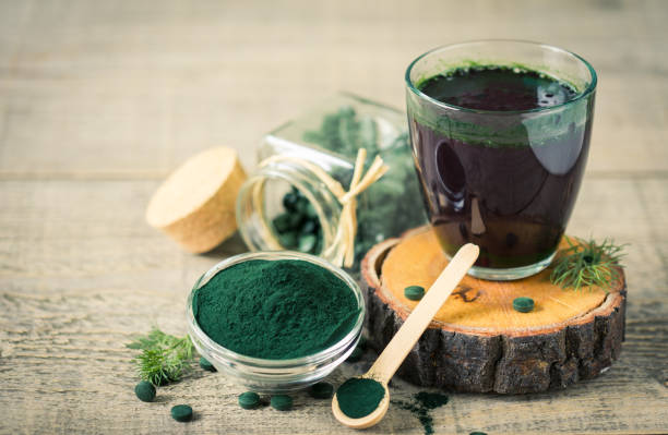 gesunde spirulina getränk im glas - chlorophyll green smoothie smoothie vegetable stock-fotos und bilder