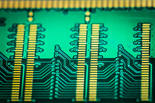 Extreme close up macro color image depicting a selective focus view of a computer circuit board.
