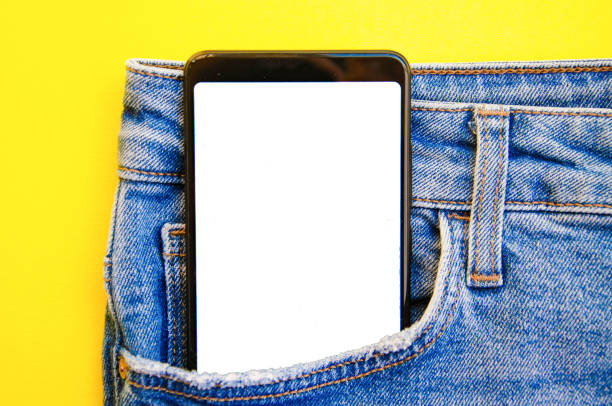 istock White screen smartphone in jeans pocket. Smartphone place for text. Smartphone in a pocket on a yellow background.  Copy Space 1222792113