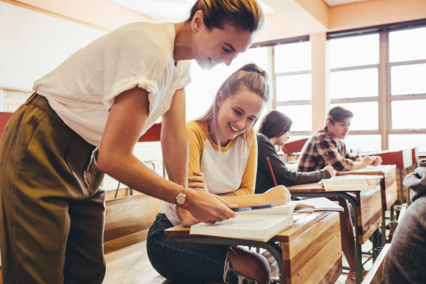 istock Teacher assisting a student in the classroom 1222792460