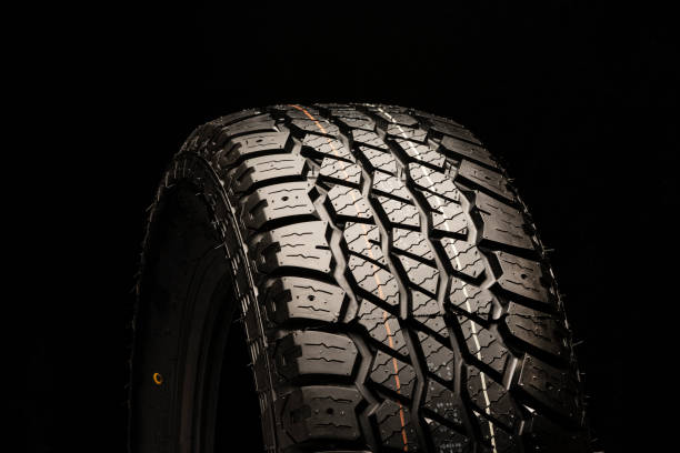 istock all terrain new tire close-up on a black background 1222792669