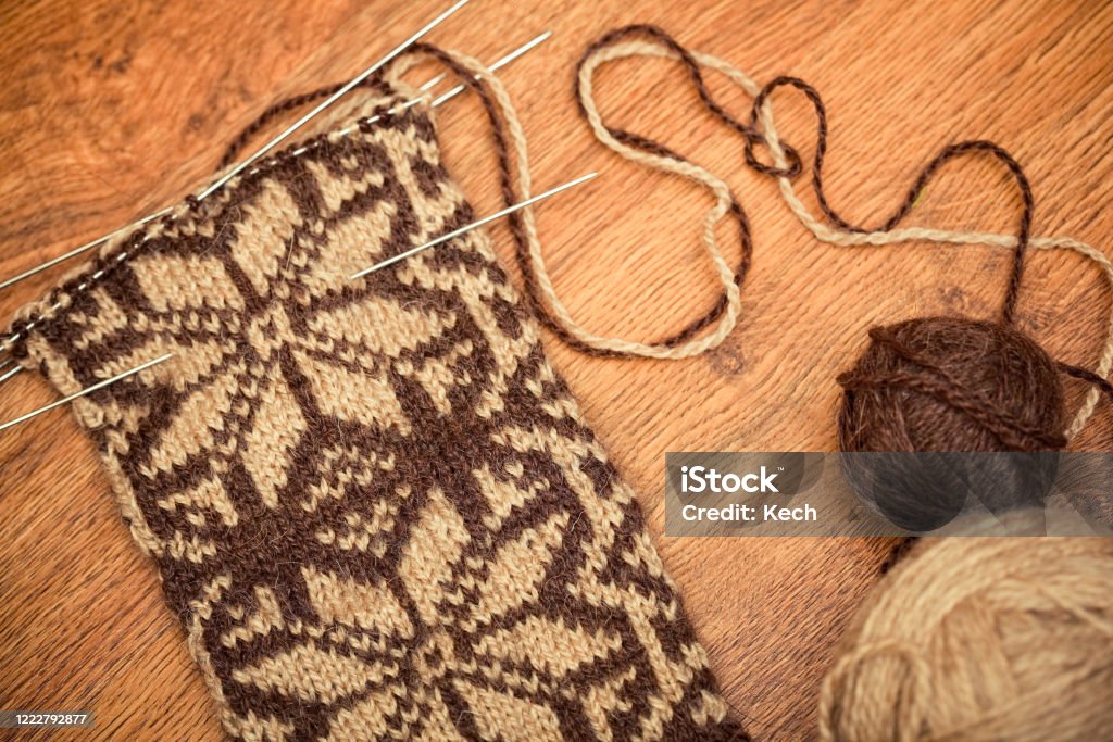 knitting lying on wooden background with needles and sewing clew Abstract Stock Photo