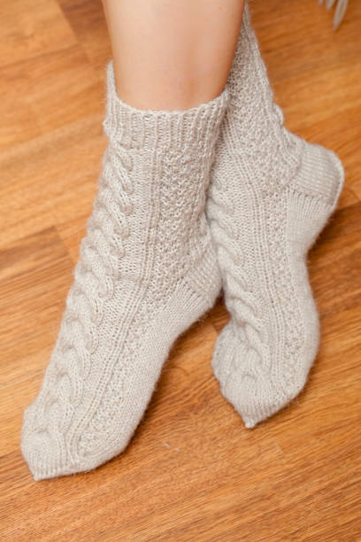 istock pair of knitted woolen socks on woman's feet 1222793468