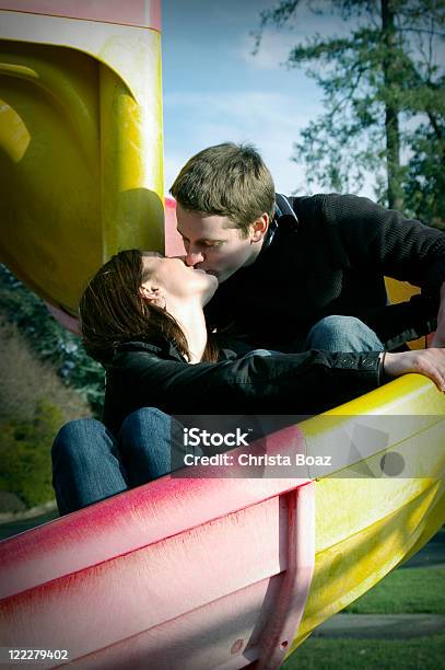 Kissing On Slide Stock Photo - Download Image Now - 20-24 Years, Adults Only, Color Image