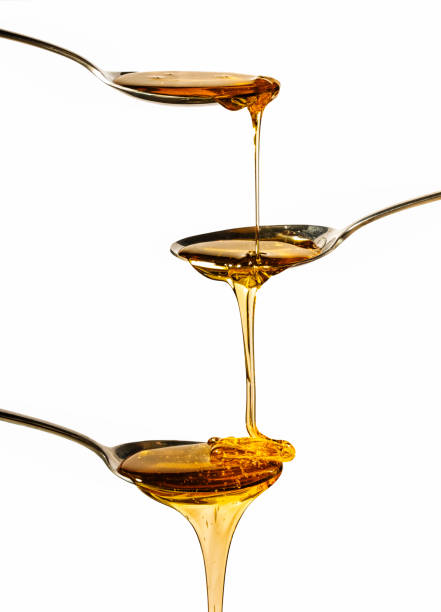 istock honey falling on metal spoons with a white background 1222794093