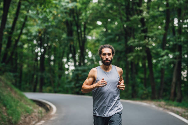istock Flattening the Curve: Man Running Alone in Nature, Looking at Camera 1222797877