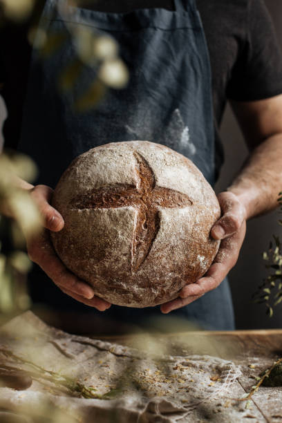 istock The Baker's hands hold a loaf of rye bread 1222798063