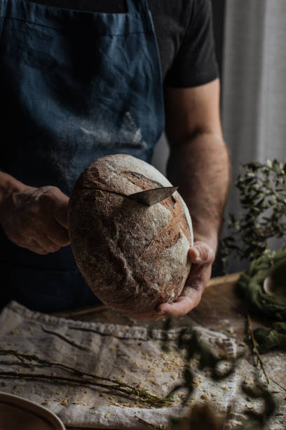 istock The Baker's hands hold a loaf of rye bread 1222798095