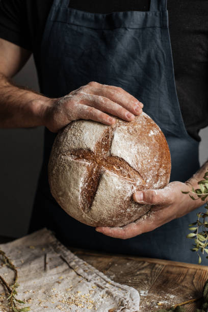 istock The Baker's hands hold a loaf of rye bread 1222798132