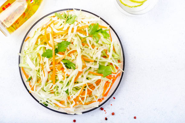istock White cabbage salad coleslaw with carrot on white kitchen table background. Top view, copy space 1222801285