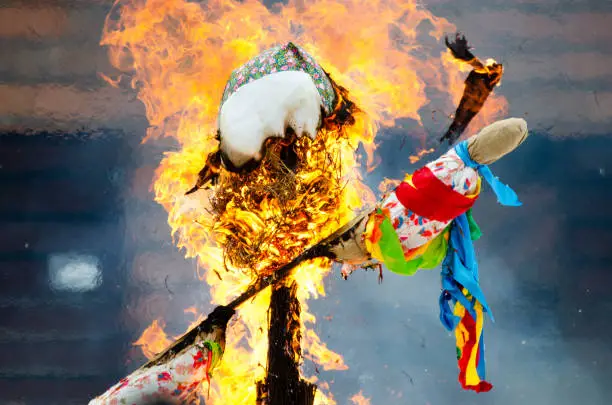 Photo of Burning effigies straw Maslenitsa in fire on traditional slavic national holiday Shrovetide.