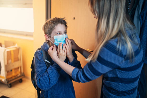 istock Mother helping son to put on mask before going to school 1222801378