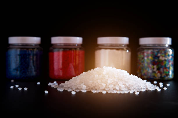 White plastic and blue plastic beads in plastic bottles on black background, Polymers bead or polymer resin, polymer pallet, Product from petrochemical plants.