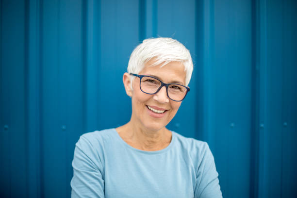 istock Happy senior woman against blue background. 1222802328