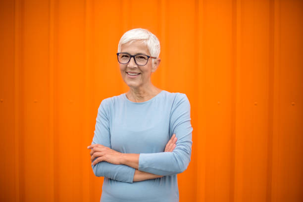 istock Happy senior woman against orange background. 1222802442